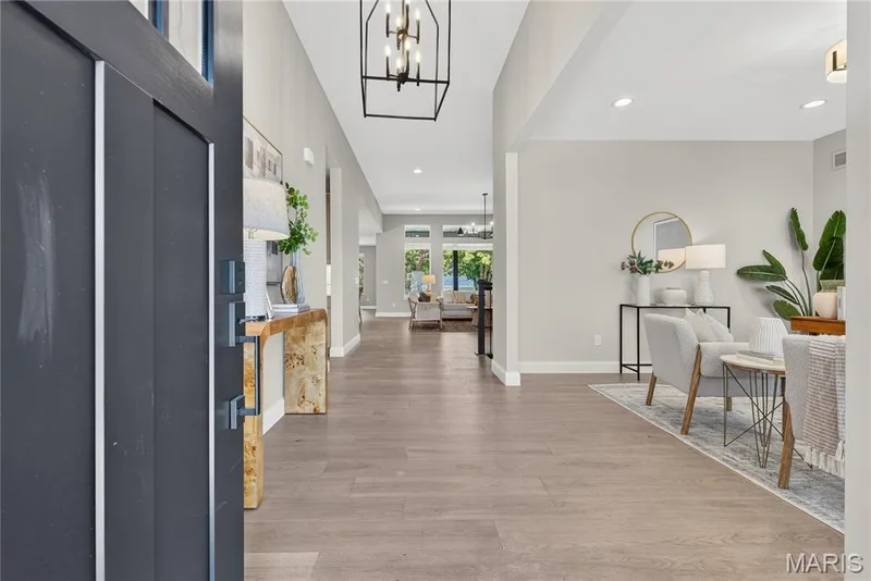 Expansive wood-finish flooring throughout, modern foyer chandelier, recessed ceiling lighting, and a broad entryway — 128 Royal Troon Drive, Dardenne Prairie, MO 63368