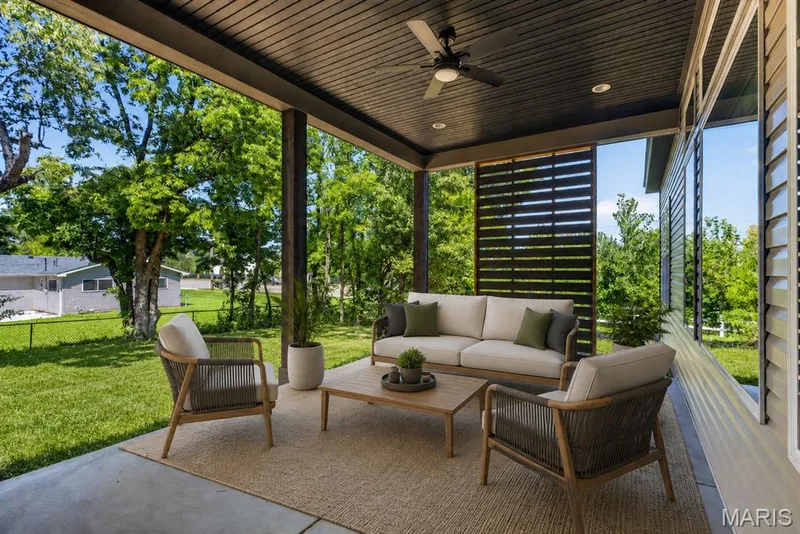Covered patio with concrete flooring, dark wood-finish ceiling, and a ceiling fan — 128 Royal Troon Drive, Dardenne Prairie, MO 63368