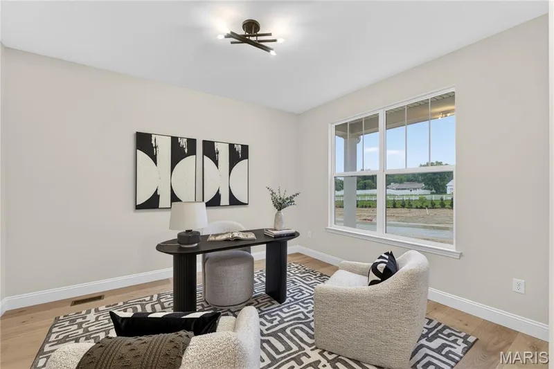 Flex room featuring light wood-finish flooring, neutral wall paint, and a large window with white trim — 366 Strawberry Grove Drive, O'Fallon, MO 63376