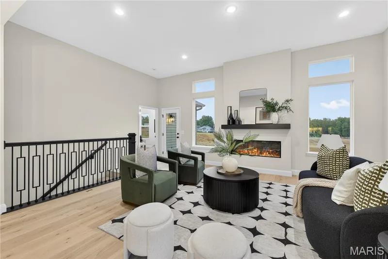Great Room featuring a linear fireplace with a floating mantel, recessed lighting, and light wood-finish flooring — 366 Strawberry Grove Drive, O'Fallon, MO 63376