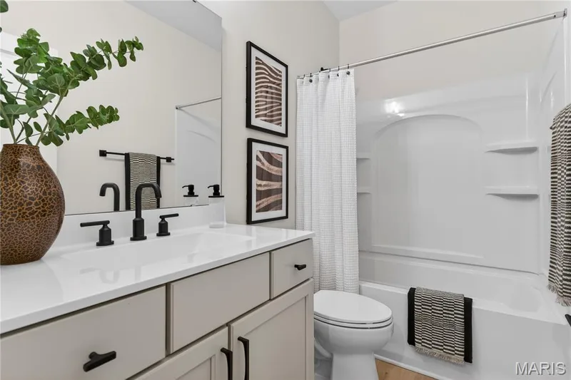 Bathroom featuring a single vanity with a white countertop, matte black fixtures, and light-toned cabinetry — 366 Strawberry Grove Drive, O'Fallon, MO 63376