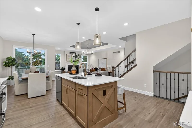 Gourmet kitchen island with white countertop, integrated sink, and pendant lighting — 369 Strawberry Grove Drive, O'Fallon, MO 63376