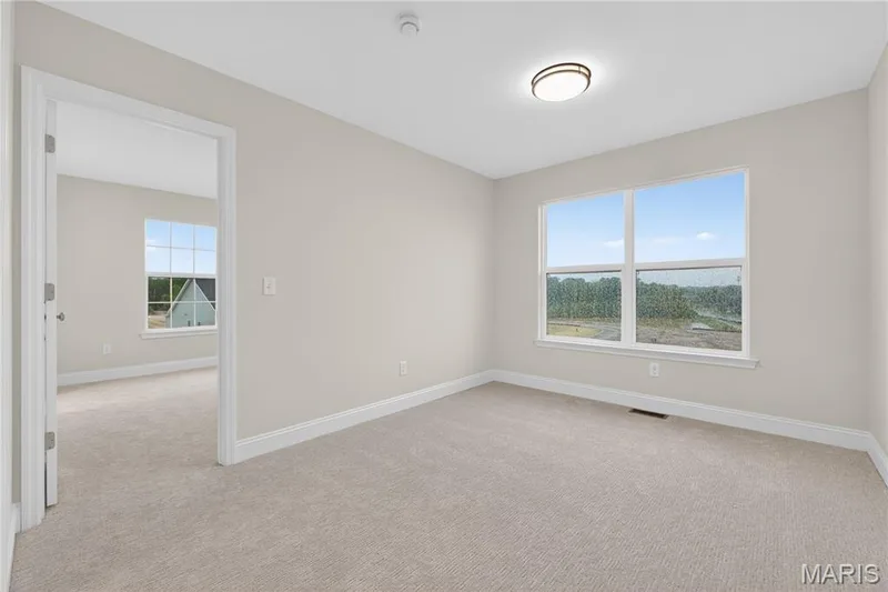 Second floor loft with a large window, white trim, and a flush-mount ceiling light — 369 Strawberry Grove Drive, O'Fallon, MO 63376