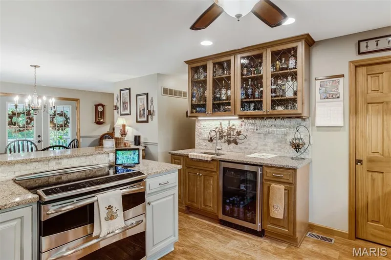 Wet bar has wine rack, glass rack, refrigerator and glass cabinets — 51 Nordic Lane, Defiance, MO 63341