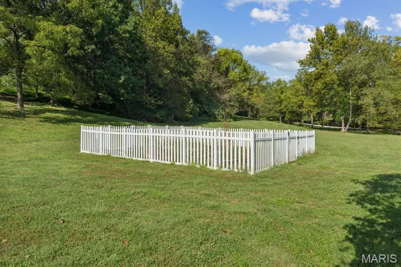 Expansive green space featuring a white picket fence enclosure and mature trees — 2333 Ossenfort Road, Wildwood, MO 63038