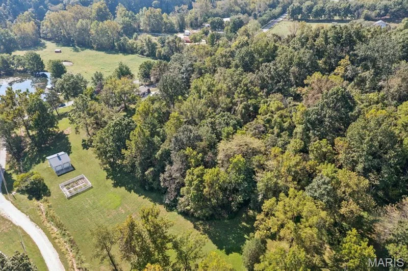 Expansive wooded property featuring a substantial pond, a small outbuilding, and a garden bed — 2333 Ossenfort Road, Wildwood, MO 63038