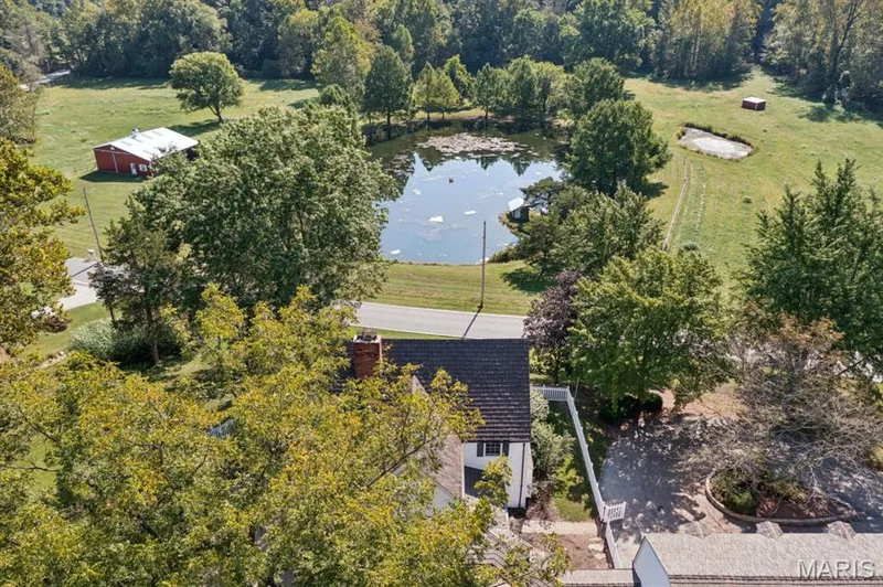 Expansive property featuring a private pond, open green spaces, mature trees, and a red barn structure — 2333 Ossenfort Road, Wildwood, MO 63038