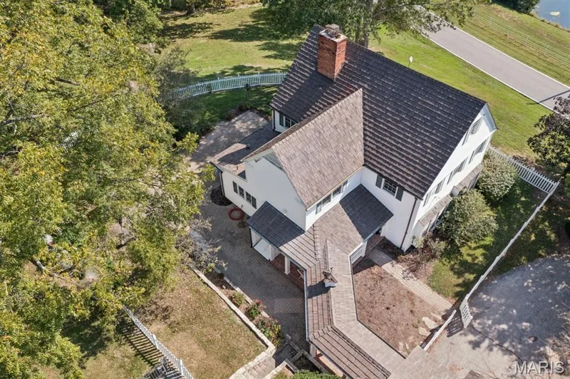 White exterior with dark shutters, multiple gables, and a prominent brick chimney — 2333 Ossenfort Road, Wildwood, MO 63038