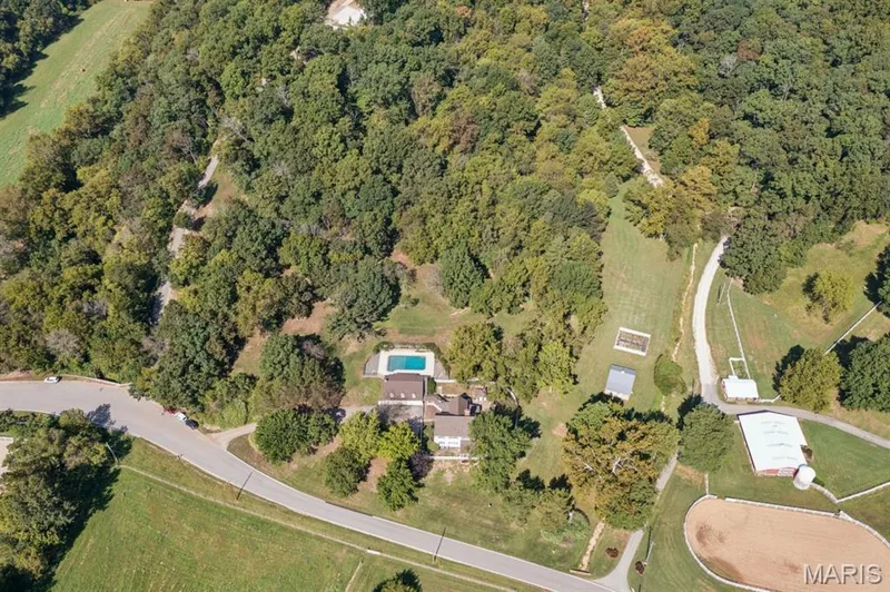 Expansive property featuring a private swimming pool, multiple outbuildings, and extensive wooded areas — 2333 Ossenfort Road, Wildwood, MO 63038