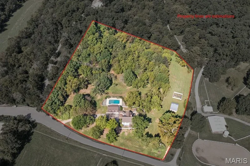 Expansive property featuring a private swimming pool, multiple outbuildings, and a large wooded area — 2333 Ossenfort Road, Wildwood, MO 63038
