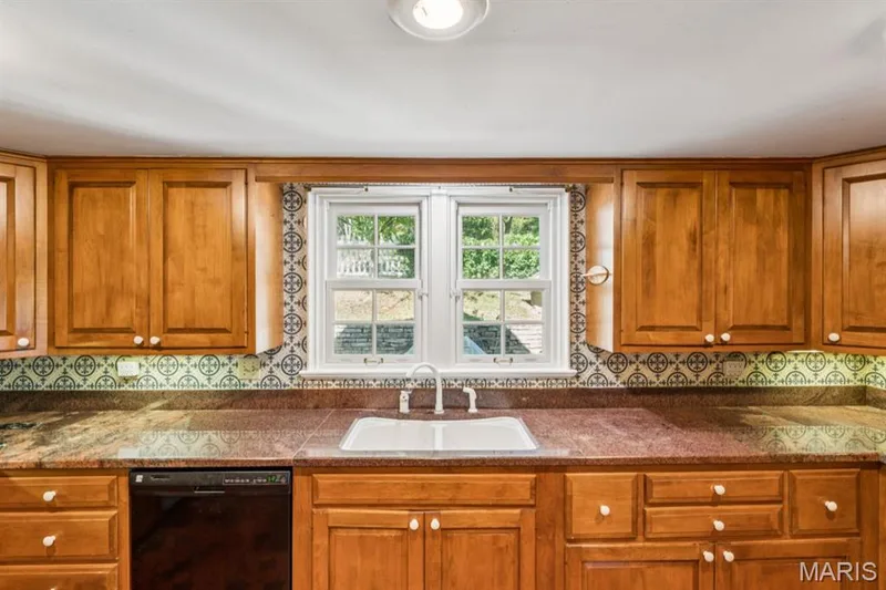 Wood-finish cabinetry with white knob hardware, a double-basin sink, and a black built-in dishwasher — 2333 Ossenfort Road, Wildwood, MO 63038