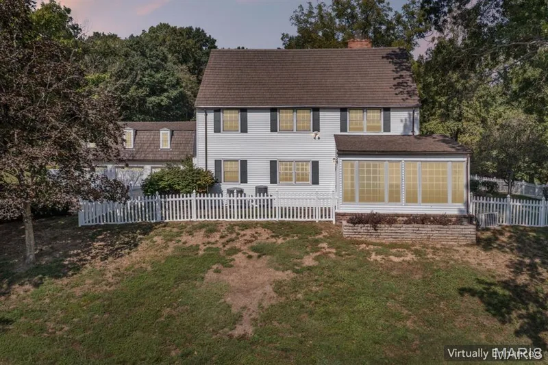 White siding exterior with dark shutters, gabled roof, and a sunroom with multiple grid windows — 2333 Ossenfort Road, Wildwood, MO 63038