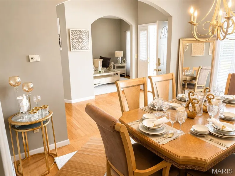 Formal dining area featuring hardwood flooring, an arched doorway, and a chandelier — 1126 Manor Cove Drive, St Charles, MO 63304