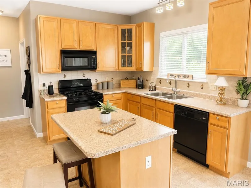 Kitchen featuring light wood cabinetry and light-toned countertops — 1126 Manor Cove Drive, St Charles, MO 63304