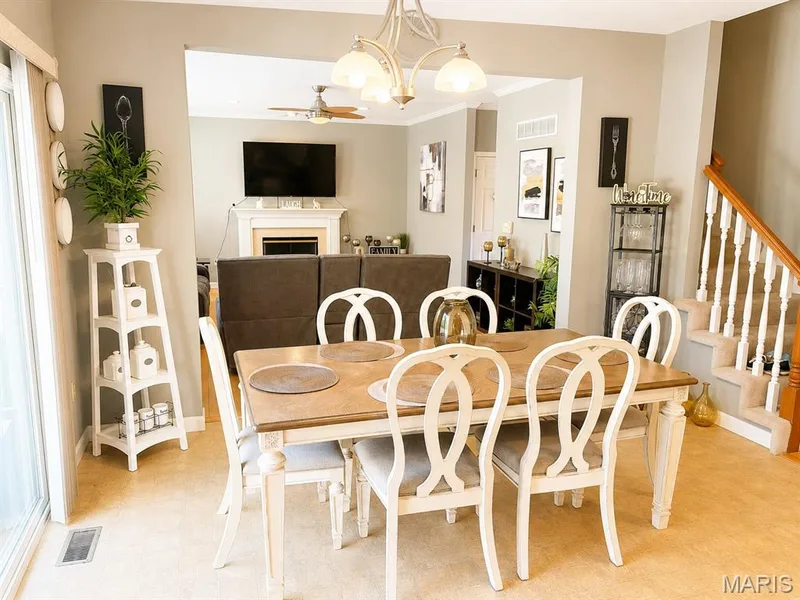 Dining area featuring a contemporary chandelier, direct access to an outdoor space via a glass sliding door, and carpeting — 1126 Manor Cove Drive, St Charles, MO 63304