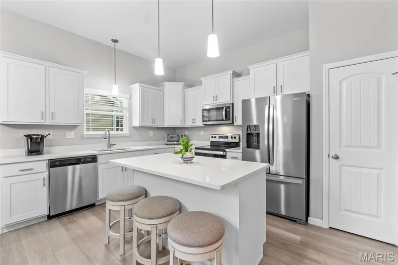 Kitchen w/ solid surface counters, pantry, staggard cabinets, stainless appliances, center island. — 1010 Timber Bluff Drive, Wentzville, MO 63385