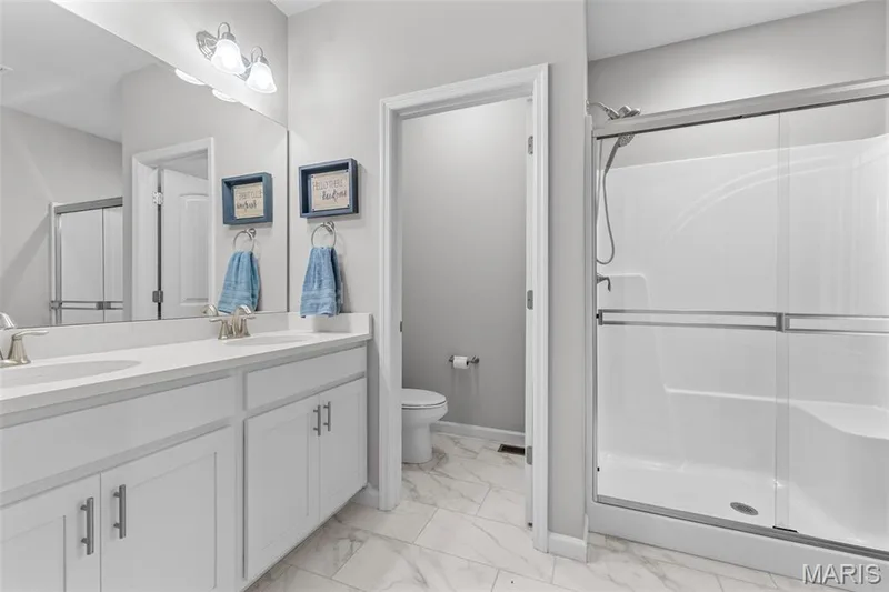 Primary Bath w/ ceramic tile, double sinks, shower w/ seat, water closet for added privacy. — 1010 Timber Bluff Drive, Wentzville, MO 63385