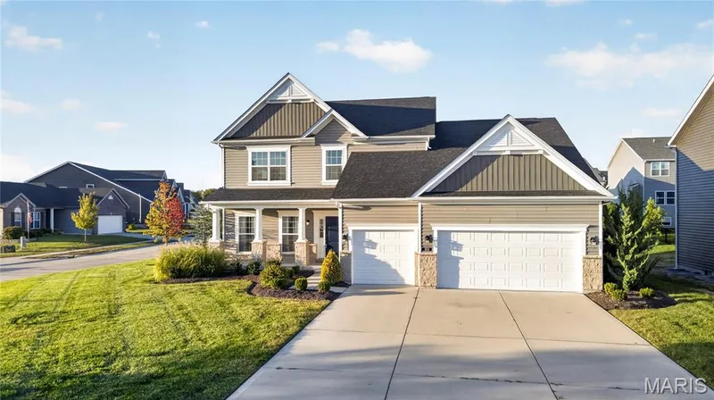 1.5-story residential structure featuring a covered front porch, a three-car garage, and a concrete driveway — 301 Healthy Way, St Charles, MO 63304