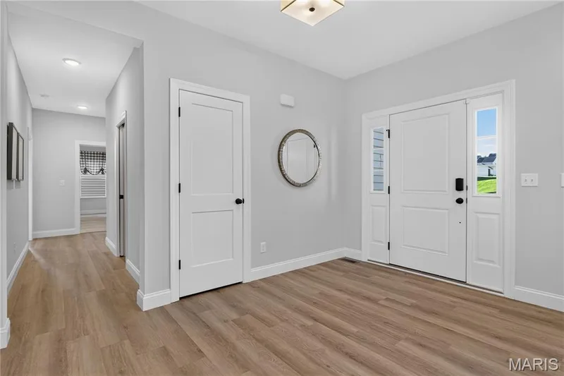 Entryway featuring a white door with sidelights, Luxury Vinyl Plank flooring, and a flush-mount ceiling fixture — 301 Healthy Way, St Charles, MO 63304