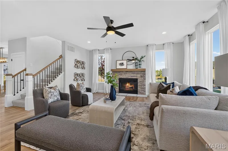 Inviting great room with wood-look flooring, recessed lighting, and a stylish ceiling fan. — 301 Healthy Way, St Charles, MO 63304