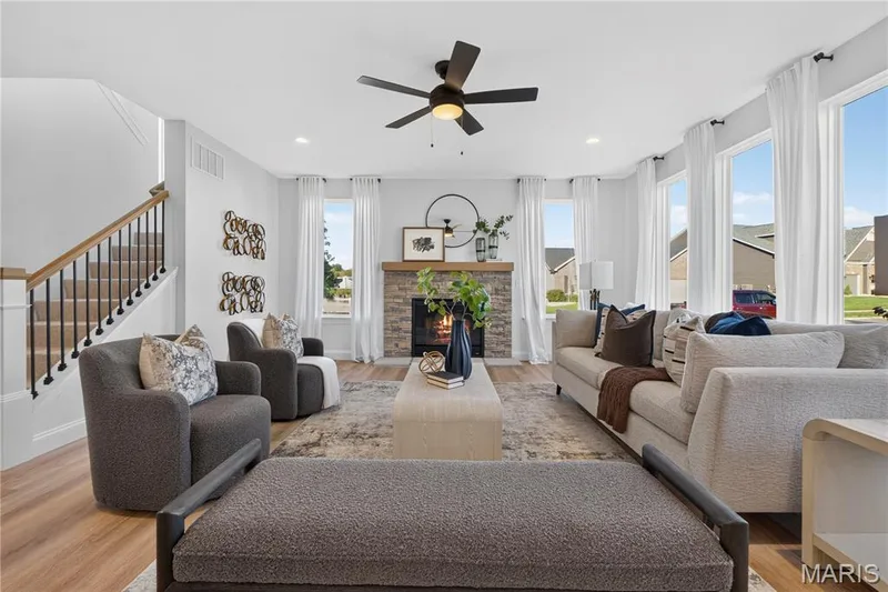 Tall windows and a warm wood mantel bring natural light and character to the great room. — 301 Healthy Way, St Charles, MO 63304