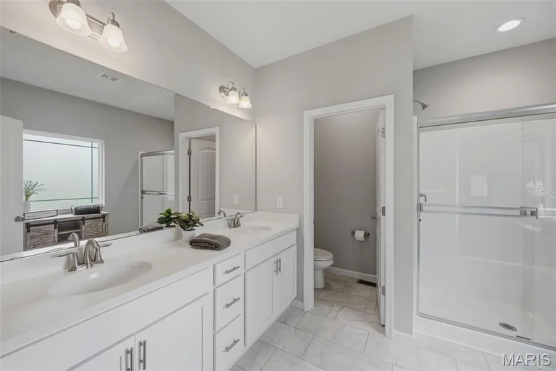 Stunning primary bathroom en suite with dual sinks — 411 Knothole Lane, Wentzville, MO 63385
