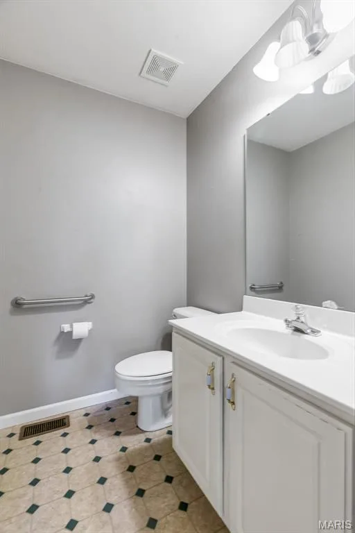 Bathroom 1/2 bath Powder room for guests- featuring a white vanity with integrated sink, chrome faucet, and mirrored medicine cabinet — 1103 Panda Court, Wentzville, MO 63385