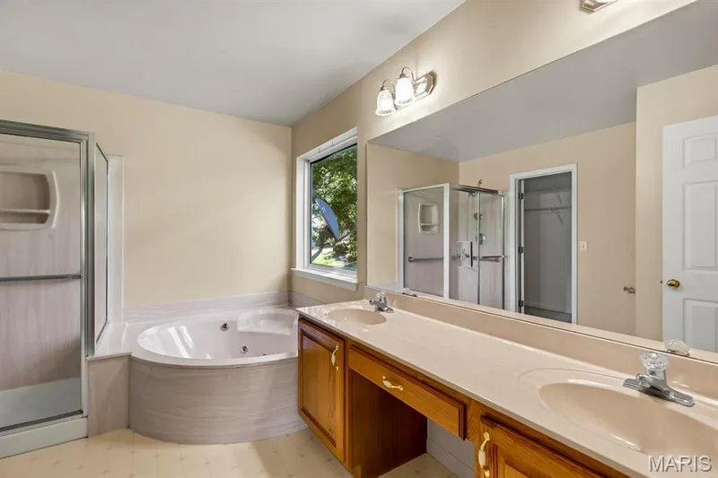 Features double sink vanity, corner jetted tub, separate shower, and walk in closet — 1103 Panda Court, Wentzville, MO 63385