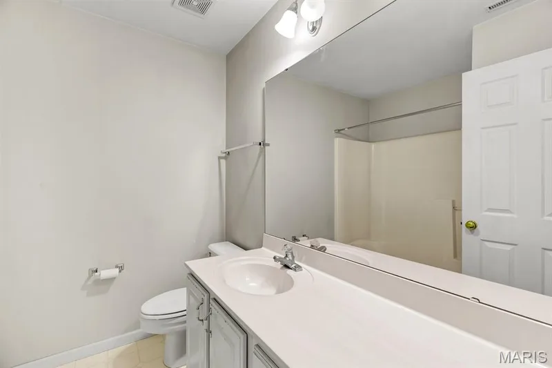 Full-width vanity mirror reflecting a shower-tub combination — 1103 Panda Court, Wentzville, MO 63385