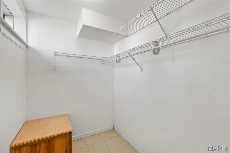 Interior storage space featuring white wire shelving, a window, and tile flooring — 1103 Panda Court, Wentzville, MO 63385