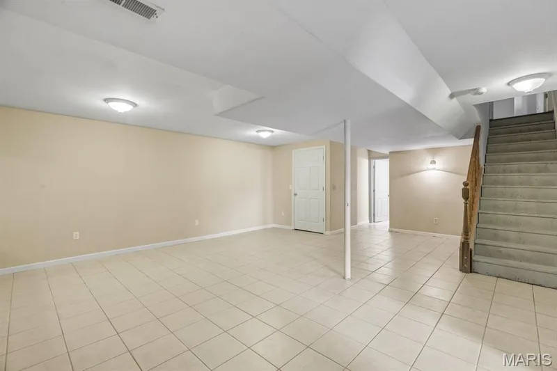 Spacious finished basement featuring light-colored tile flooring, neutral wall paint, and recessed lighting — 1103 Panda Court, Wentzville, MO 63385