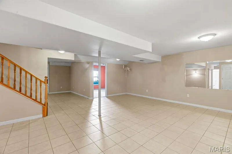 Spacious finished basement featuring light-colored tile flooring, neutral wall paint, and recessed lighting — 1103 Panda Court, Wentzville, MO 63385