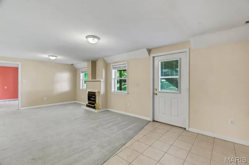 Spacious finished basement featuring light-colored tile flooring, neutral wall paint, and recessed lighting, Fireplace and Walk out to large patio — 1103 Panda Court, Wentzville, MO 63385