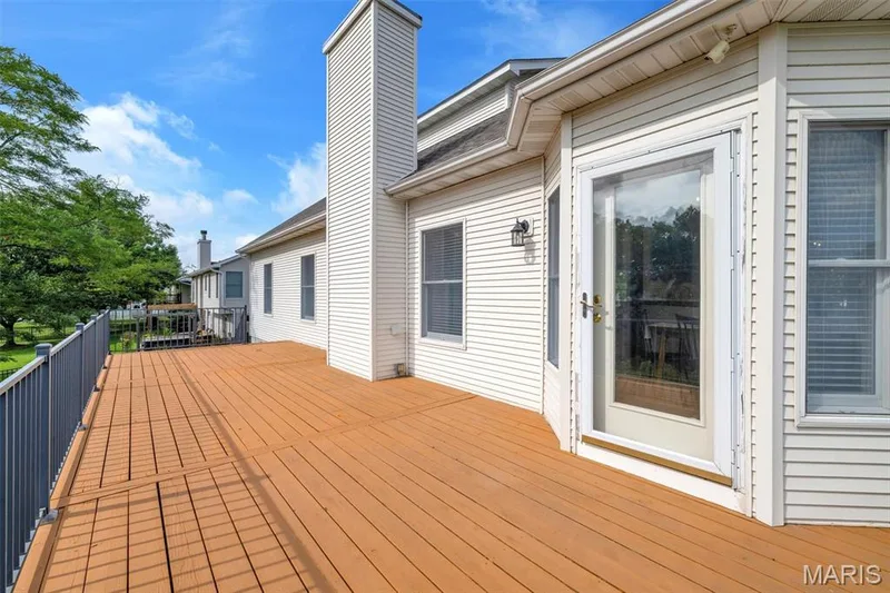 Expansive outdoor deck featuring wood-finish flooring and a metal railing — 195 England Drive, O'Fallon, MO 63366