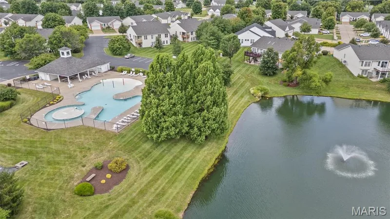 Community swimming pool with an adjacent covered pavilion, surrounded by lounge seating and a fenced perimeter — 195 England Drive, O'Fallon, MO 63366