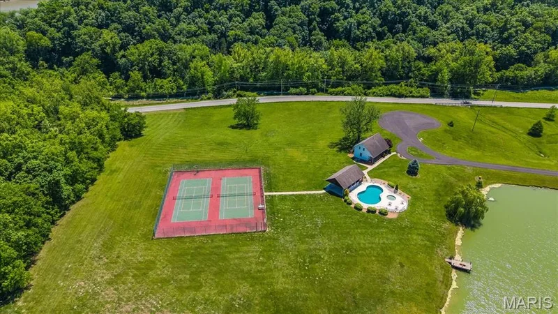 Community tennis and pickelball courts, inground swimming pool, and hot tub next to a pond near the front of the community — 4444 Augusta Shores Drive, Augusta, MO 63332