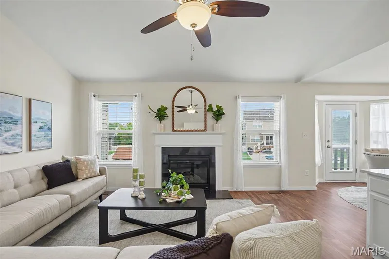 Open great room featuring a vaulted ceiling, LVP flooring, and a cozy gas fireplace — 18 Sonnet Way Court, Wentzville, MO 63385