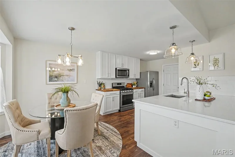 Fresh, bright, open kitchen featuring a custom oversized island with abundant storage, quartz countertops, SS appliances, and a walk-in pantry — 18 Sonnet Way Court, Wentzville, MO 63385