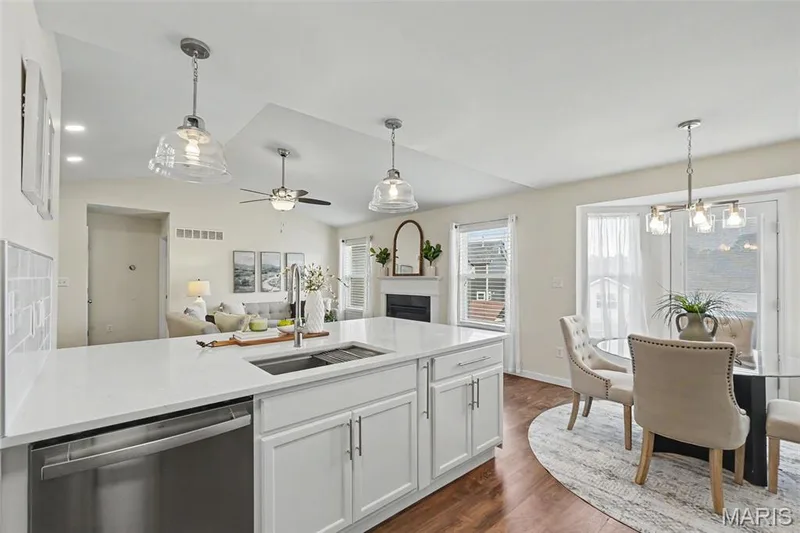 Fresh, bright, open kitchen featuring a custom oversized island with abundant storage, quartz countertops, SS appliances, and a walk-in pantry — 18 Sonnet Way Court, Wentzville, MO 63385