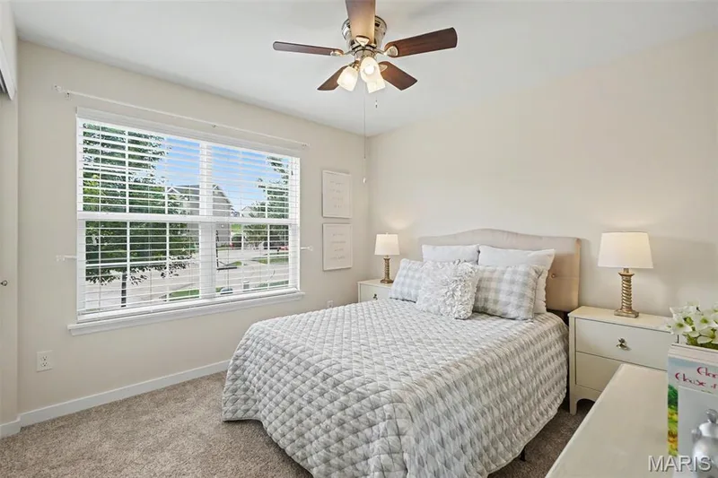 Secondary bedroom featuring new plush carpeting and a ceiling fan — 18 Sonnet Way Court, Wentzville, MO 63385