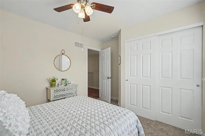 Secondary bedroom featuring new plush carpeting and a ceiling fan — 18 Sonnet Way Court, Wentzville, MO 63385