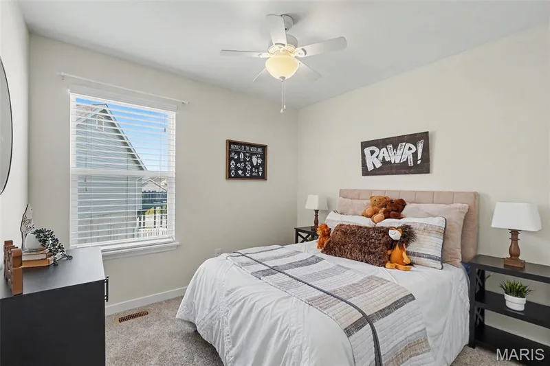 Secondary bedroom featuring new plush carpeting and a ceiling fan — 18 Sonnet Way Court, Wentzville, MO 63385