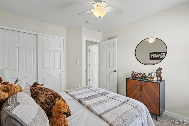 Secondary bedroom featuring new plush carpeting and a ceiling fan — 18 Sonnet Way Court, Wentzville, MO 63385