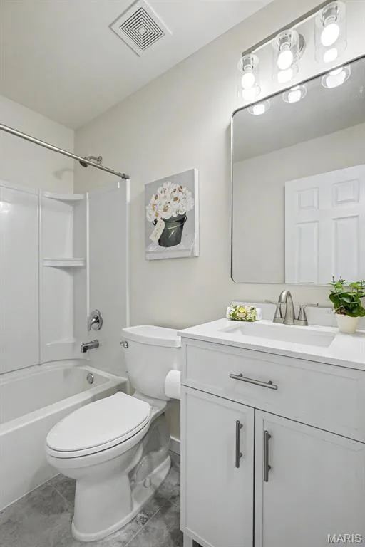 Renovated main-floor hall bath with ceramic tile flooring, new vanity, mirror, lighting, and an elongated commode — 18 Sonnet Way Court, Wentzville, MO 63385