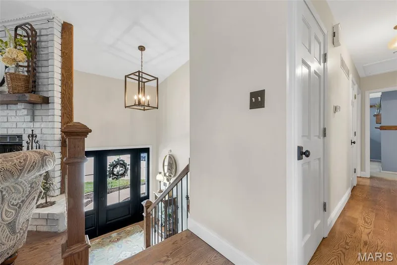 Refinished in solid oak flooring, stunning 6 panel door with sidelights, wrought iron spindle banister and chandelier — 16 La Rochelle Court, Lake St. Louis, MO 63367
