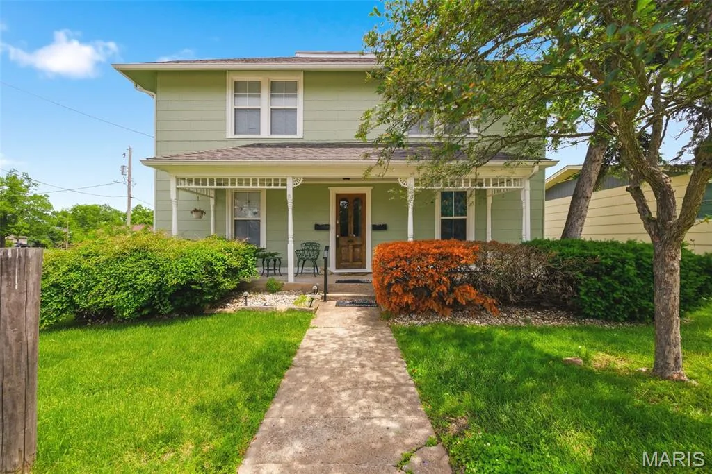 Two-story residence featuring a covered front porch with decorative white columns and railings — 502 S Linn Avenue, Wentzville, MO 63385