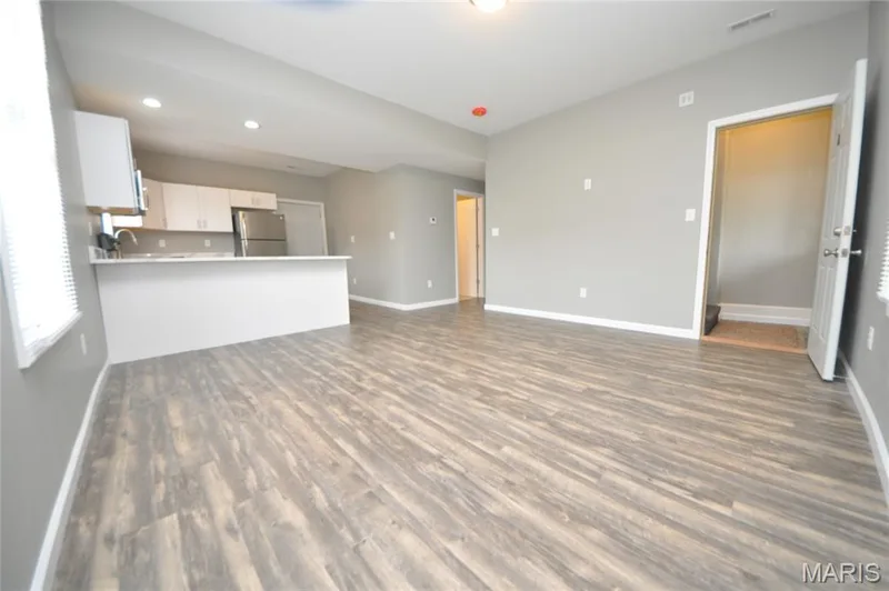 Open-concept living space with wood-finish flooring — 502 S Linn Avenue, Wentzville, MO 63385