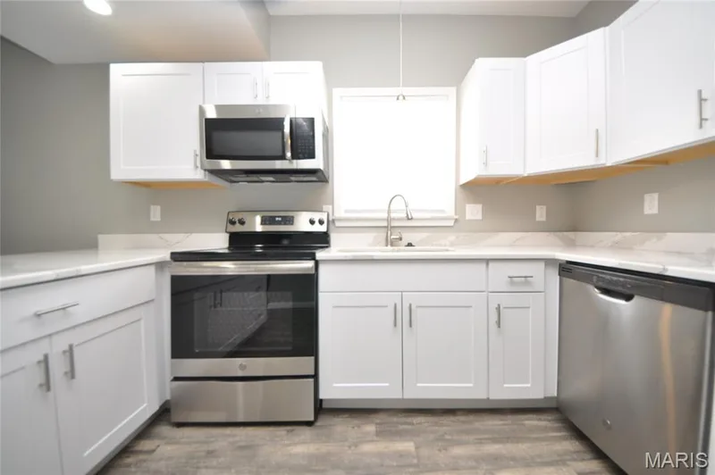 Modern kitchen featuring white shaker cabinetry and coordinating light countertops — 502 S Linn Avenue, Wentzville, MO 63385