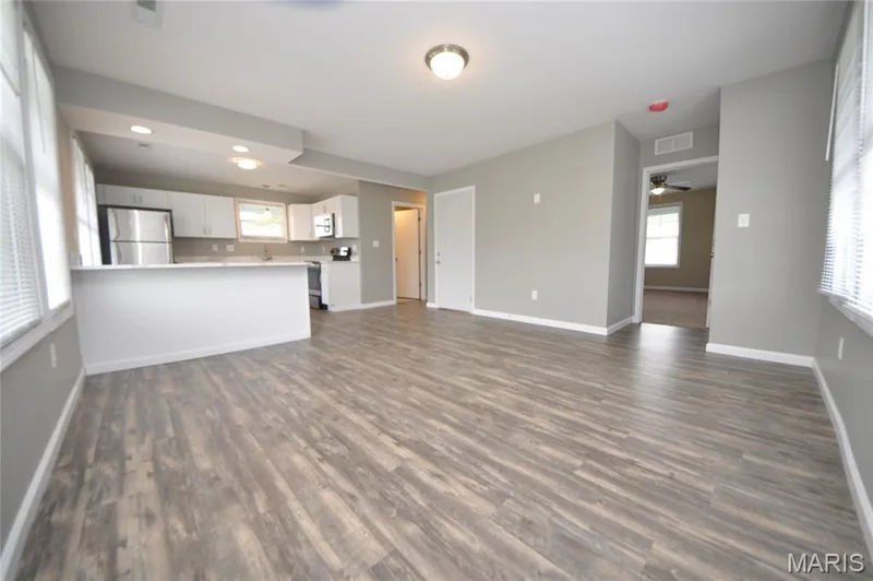 Spacious open-concept interior featuring wood-finish flooring throughout — 502 S Linn Avenue, Wentzville, MO 63385