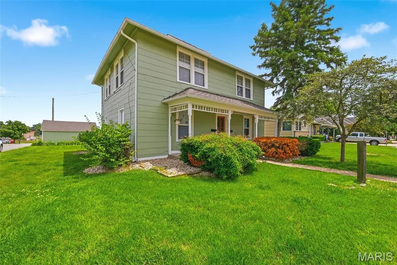 Two-story home with light green siding and white trim windows — 502 S Linn Avenue, Wentzville, MO 63385